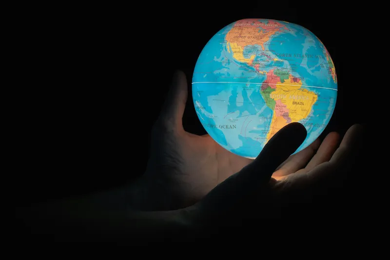 A pair of hands holding a globe